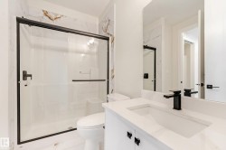 Bathroom featuring a white vanity with an integrated rectangular sink, a black single-handle faucet, and black cabinet hardware - 