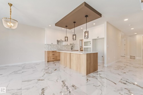Open-concept kitchen and living area featuring marble-look large format tile flooring - 4015 39 Street, Beaumont, AB - Indoor Photo Showing Kitchen