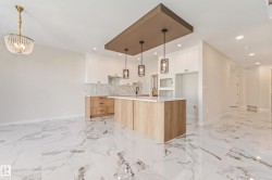 Open-concept kitchen and living area featuring marble-look large format tile flooring - 