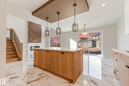 Kitchen island with a white countertop and wood-finish cabinetry - 4015 39 Street, Beaumont, AB - Indoor Photo Showing Kitchen