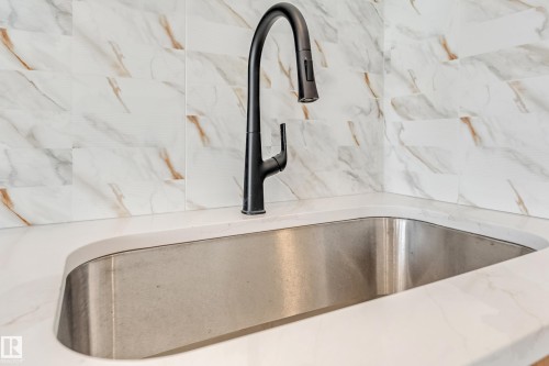 Stainless steel undermount sink with a matte black gooseneck faucet - 4015 39 Street, Beaumont, AB - Indoor