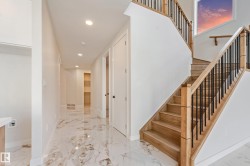 Open staircase with natural wood treads and risers, black metal balusters, and a matching wood handrail - 