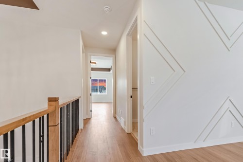 Hallway featuring wood-finish flooring, recessed lighting, and white walls with decorative trim detailing - 4015 39 Street, Beaumont, AB - Indoor Photo Showing Other Room