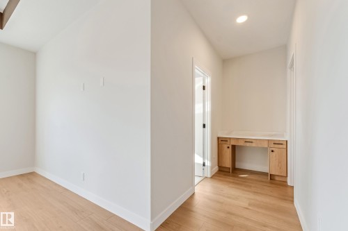 Hallway featuring wood-finish flooring and a built-in desk with a light-toned countertop - 4015 39 Street, Beaumont, AB - Indoor Photo Showing Other Room