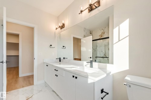 Double vanity with white cabinetry, integrated sinks, and black fixtures - 4015 39 Street, Beaumont, AB - Indoor Photo Showing Bathroom