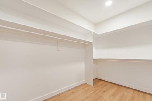 Built-in closet system featuring white shelving and hanging rods - 4015 39 Street, Beaumont, AB - Indoor