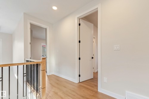 Hallway featuring wood-finish flooring, recessed lighting, and a contemporary stair railing with wood handrail and black spindles - 4015 39 Street, Beaumont, AB - Indoor Photo Showing Other Room