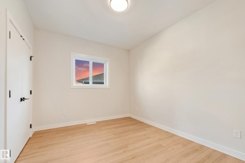 Bright room featuring light wood-finish flooring, white walls, and a single window with white trim - 4015 39 Street, Beaumont, AB - Indoor Photo Showing Other Room