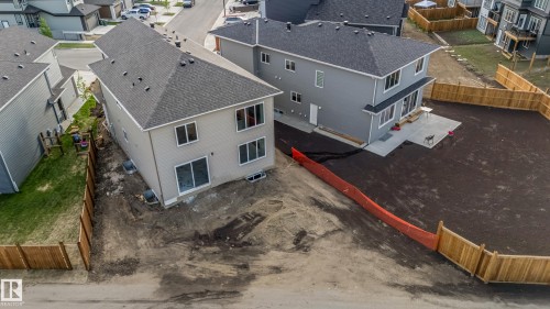 Rear exterior of a residence featuring light gray siding and a dark shingle roof - 4015 39 Street, Beaumont, AB - Outdoor