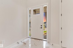 Entryway featuring a white door with transom and sidelight windows, black hardware, and polished marble-look flooring - 