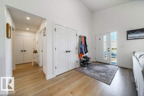 Entryway featuring light wood-finish flooring, a white front door with vertical window panels, a side light, and vaulted ceilings - 11303 111 Avenue, Edmonton, AB - Indoor Photo Showing Other Room