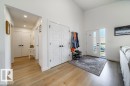 Entryway featuring light wood-finish flooring, a white front door with vertical window panels, a side light, and vaulted ceilings - 11303 111 Avenue, Edmonton, AB  - Indoor Photo Showing Other Room 