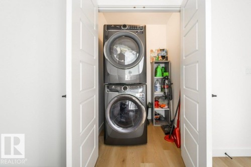 Dedicated laundry area featuring stacked front-load machines - 11303 111 Avenue, Edmonton, AB - Indoor Photo Showing Laundry Room