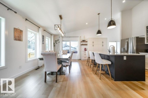 Open-concept living space with vaulted ceilings, light wood-finish flooring, and abundant natural light from multiple windows - 11303 111 Avenue, Edmonton, AB - Indoor
