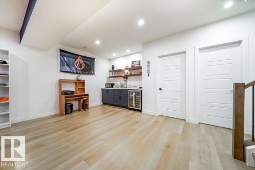 Light wood-finish flooring complements the bright white walls and recessed lighting - 11303 111 Avenue, Edmonton, AB - Indoor