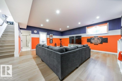 Spacious finished basement featuring light wood-finish flooring, recessed ceiling lighting, and a contemporary color palette - 11303 111 Avenue, Edmonton, AB - Indoor