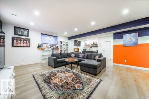 Bright recreational space featuring overhead recessed lighting, light wood-finish flooring, and built-in shelving - 11303 111 Avenue, Edmonton, AB - Indoor
