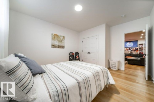 Bright room featuring light wood-finish flooring, white walls, and a ceiling-mounted light fixture - 11303 111 Avenue, Edmonton, AB - Indoor Photo Showing Bedroom