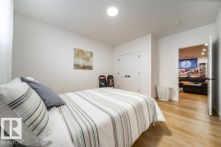 Bright room featuring light wood-finish flooring, white walls, and a ceiling-mounted light fixture - 