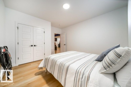 Bright interior space featuring white walls and wood-finish flooring - 11303 111 Avenue, Edmonton, AB - Indoor Photo Showing Bedroom