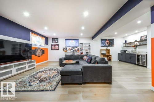 Spacious recreation room featuring recessed lighting, light wood-finish flooring, and a built-in media console with storage - 11303 111 Avenue, Edmonton, AB - Indoor