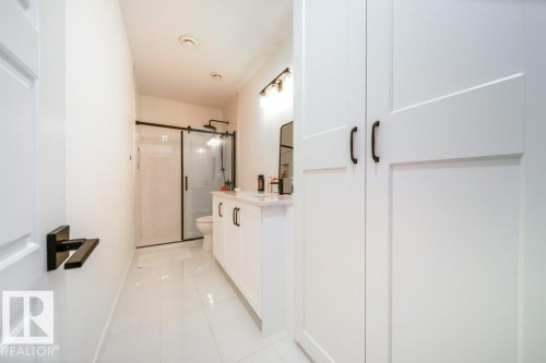 Modern bathroom featuring a single vanity with white cabinetry and a light-colored countertop - 11303 111 Avenue, Edmonton, AB - Indoor