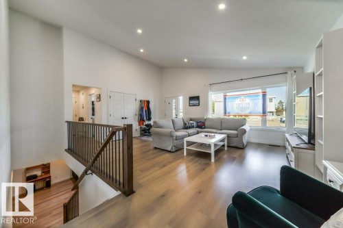 Open-concept living area featuring light wood-finish flooring, recessed lighting, and a large multi-pane window - 11303 111 Avenue, Edmonton, AB - Indoor Photo Showing Other Room
