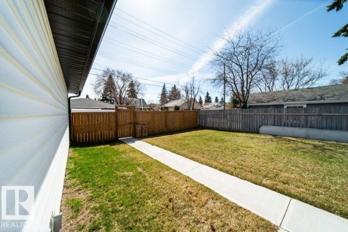 Expansive yard featuring a concrete pathway, a wood picket fence, and established trees - 11303 111 Avenue, Edmonton, AB - Outdoor