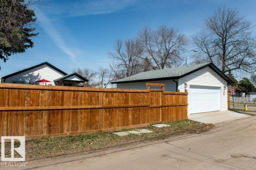 Detached garage with white siding, asphalt shingle roof, and concrete driveway - 11303 111 Avenue, Edmonton, AB - Outdoor