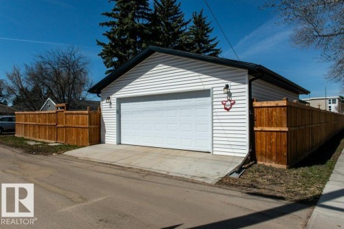 Detached two-car garage featuring white horizontal siding, a black shingled roof, and a concrete drive - 11303 111 Avenue, Edmonton, AB - Outdoor