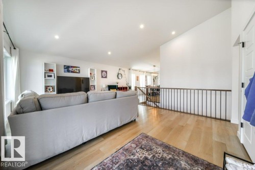 Bright, open-concept living area featuring blonde wood-finish flooring and recessed ceiling lights - 11303 111 Avenue, Edmonton, AB - Indoor