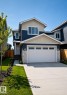Contemporary two-story residence featuring a two-car garage, stone veneer accents, and a concrete driveway - 163 Starling Way, Fort Saskatchewan, AB  - Outdoor With Facade 