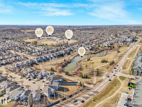 Aerial view of a residential community featuring a network of streets, detached homes, and townhomes - 322 1520 Hammond Gate Nw, Edmonton, AB - Outdoor With View