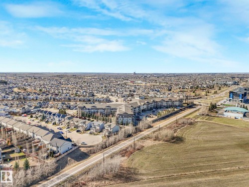 Expansive aerial showing a residential area with varied housing types, including multi-story townhomes and apartment buildings - 322 1520 Hammond Gate Nw, Edmonton, AB - Outdoor With View