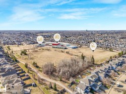 Aerial perspective showcasing suburban development with residential properties, a large open field, and institutional buildings - 