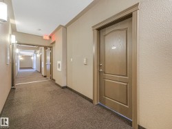 Contemporary hallway featuring textured neutral-toned walls, recessed lighting, and sconce fixtures - 
