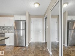Kitchen with white cabinetry, stainless steel appliances, and a mosaic tile backsplash - 