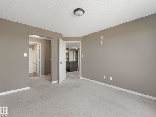 Carpeted room with neutral wall paint and white trim - 322 1520 Hammond Gate Nw, Edmonton, AB - Indoor Photo Showing Other Room