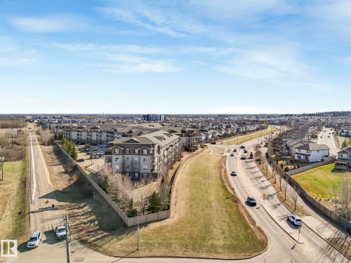 Expansive aerial perspective showcasing a neighborhood with a mix of multi-family and single-family residential properties - 322 1520 Hammond Gate Nw, Edmonton, AB - Outdoor With View