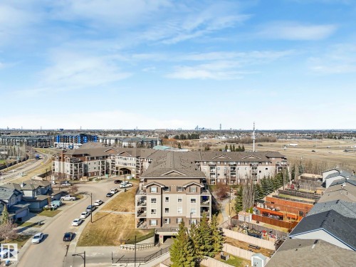 Aerial property overview showcasing a residential community with multi-story apartment buildings and single-family homes - 322 1520 Hammond Gate Nw, Edmonton, AB - Outdoor With View
