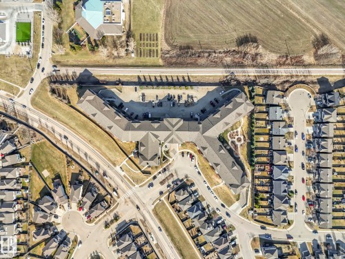 Aerial overview of a multi-unit residential property with a distinctive "V" shaped footprint, featuring multiple parking areas and surrounding roadways - 322 1520 Hammond Gate Nw, Edmonton, AB -  Photo Showing Other Room