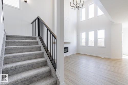 Grayscale carpeted staircase with a black metal spindle railing - 6275 180 Avenue Nw, Edmonton, AB - Indoor Photo Showing Other Room