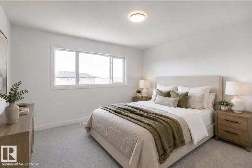 Spacious bedroom featuring light-colored carpeting, white painted walls, a large window with white trim, and an overhead flush-mount light fixture - 6275 180 Avenue Nw, Edmonton, AB - Indoor Photo Showing Bedroom