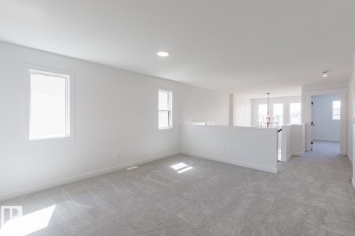 Open loft area featuring light gray carpeting and white walls - 6275 180 Avenue Nw, Edmonton, AB - Indoor Photo Showing Other Room