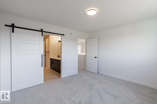 Spacious room featuring light gray carpeting, crisp white walls, and a recessed ceiling light - 6275 180 Avenue Nw, Edmonton, AB - Indoor