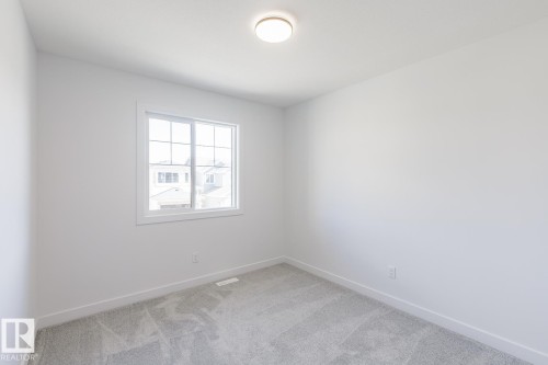 Neutral white walls, plush gray carpeting, and a grid-pane window providing ambient light - 6275 180 Avenue Nw, Edmonton, AB - Indoor Photo Showing Other Room