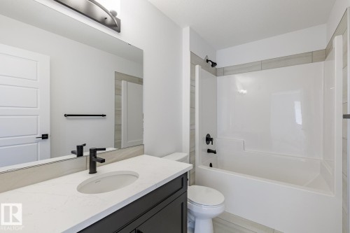 Modern bathroom featuring a single vanity with a quartz-finish countertop and undermount sink - 6275 180 Avenue Nw, Edmonton, AB - Indoor Photo Showing Bathroom