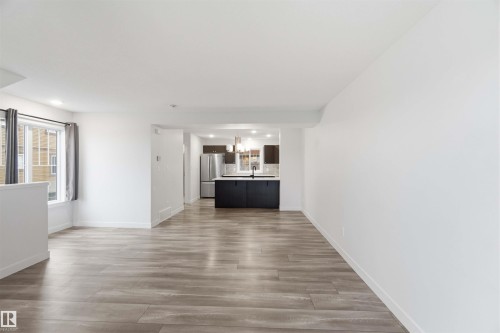 Spacious interior featuring wood-finish flooring, white walls, and recessed lighting - 36 1005 Graydon Hill Boulevard, Edmonton, AB 