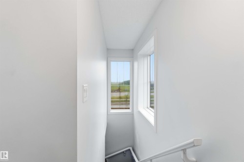 Stairwell featuring white walls, white trim, and a white handrail - 36 1005 Graydon Hill Boulevard, Edmonton, AB 