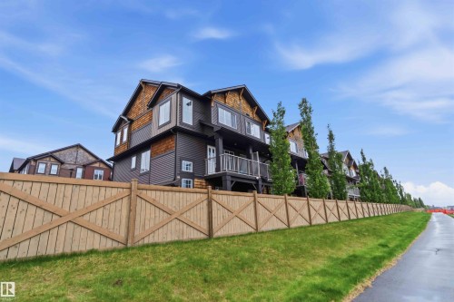 Row of townhomes featuring multi-level facades, private balconies with metal railings, and a consistent brown and wood-shingle exterior palette - 36 1005 Graydon Hill Boulevard, Edmonton, AB 
